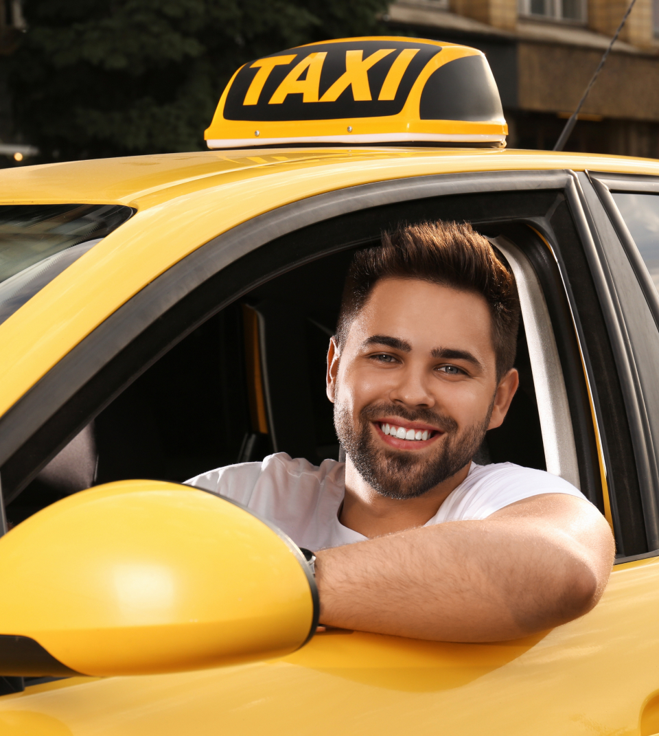 A taxi driver is looking outside through his car window