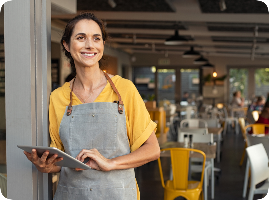 A restaurant entrepreneur holding a tablet device, standing at the restaurant