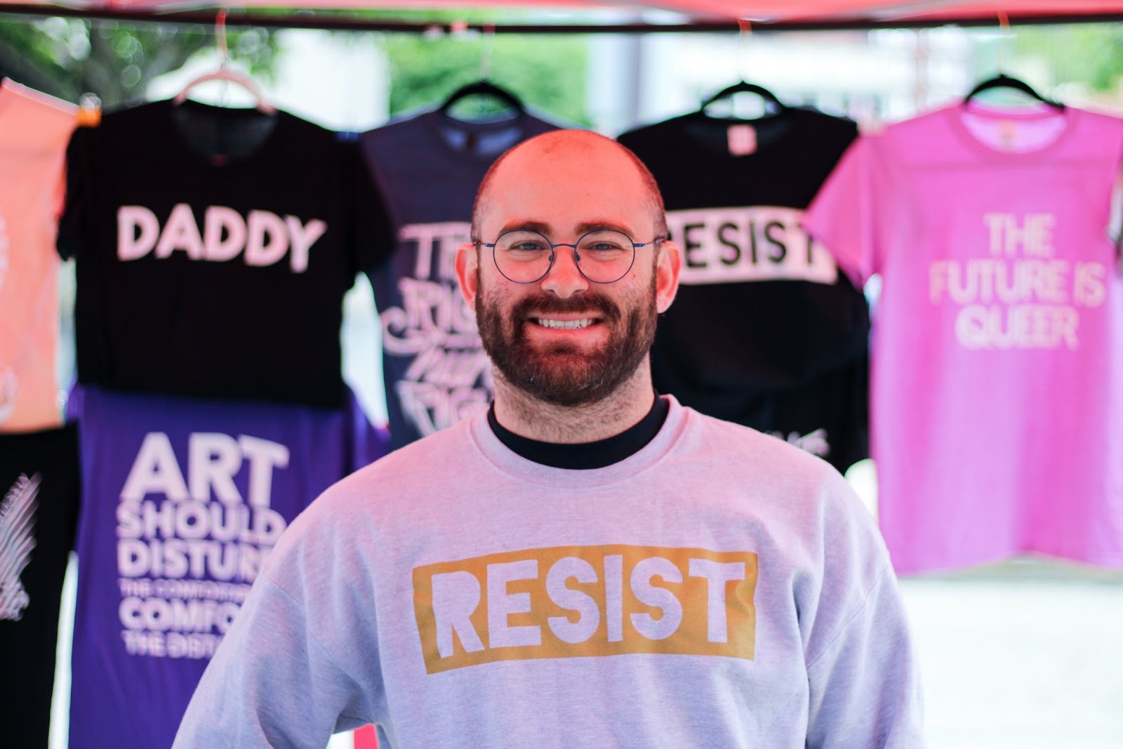 t-shirt seller with t-shirts in background