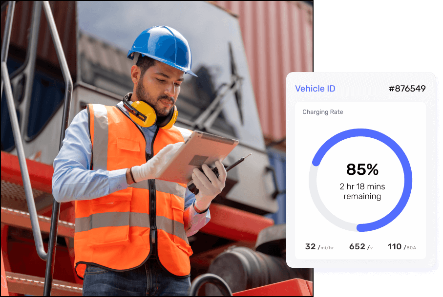 A construction worker in a hard hat and high-visibility vest is operating a tablet. The tablet displays electric vehicle charging information, including Vehicle ID #876549, a Charging Rate at 85% with 2 hours and 18 minutes remaining, and a charging speed of 32 miles per hour equivalent at 65.2 kWh and 110/120V.