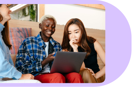 A group of people sitting on a couch and looking at the laptop screen