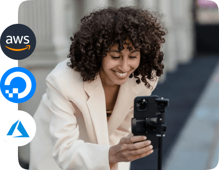 A person is operating a camera on a tripod, with icons of AWS, DigitalOcean and Microsoft Azure on the left side of the image.
